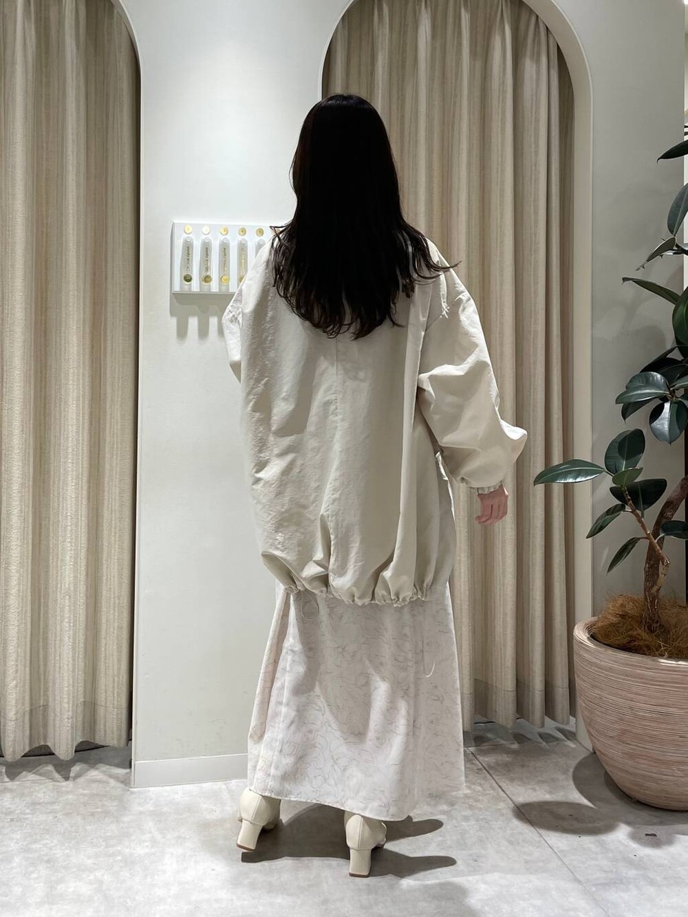 ホワイト系のブーツ、ベージュ系のワンピース、ホワイト系のブルゾンを着用したレディースの冬コーディネートの2枚目の写真