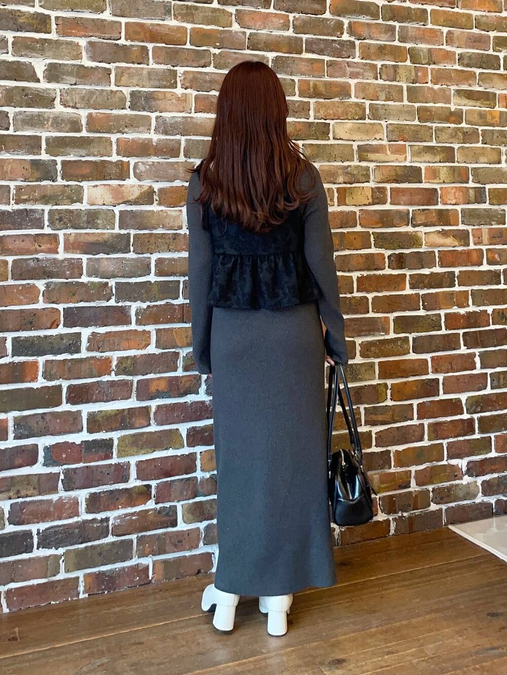 ブラック系のブルゾン、ホワイト系のブーツ、ブラック系のハンドバッグを着用したレディースの秋コーディネートの4枚目の写真