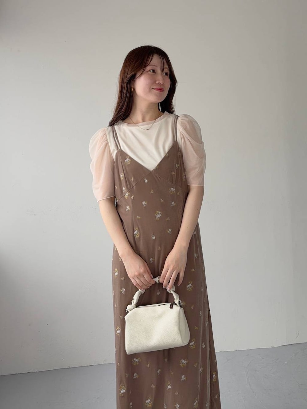 ベージュ系のサンダル、ベージュ系のワンピース、ホワイト系のTシャツ/カットソーを着用したレディースの夏コーディネートの3枚目の写真