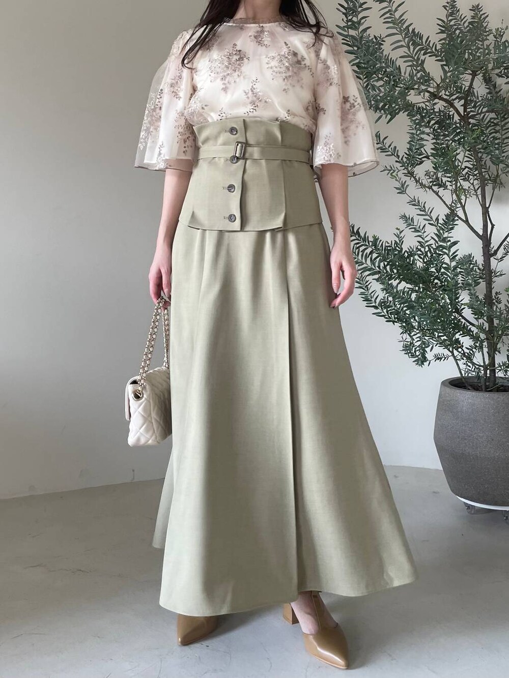 ホワイト系のシャツ/ブラウス、ホワイト系のショルダーバッグ、ベージュ系のパンプスを着用したレディースの春コーディネートの4枚目の写真