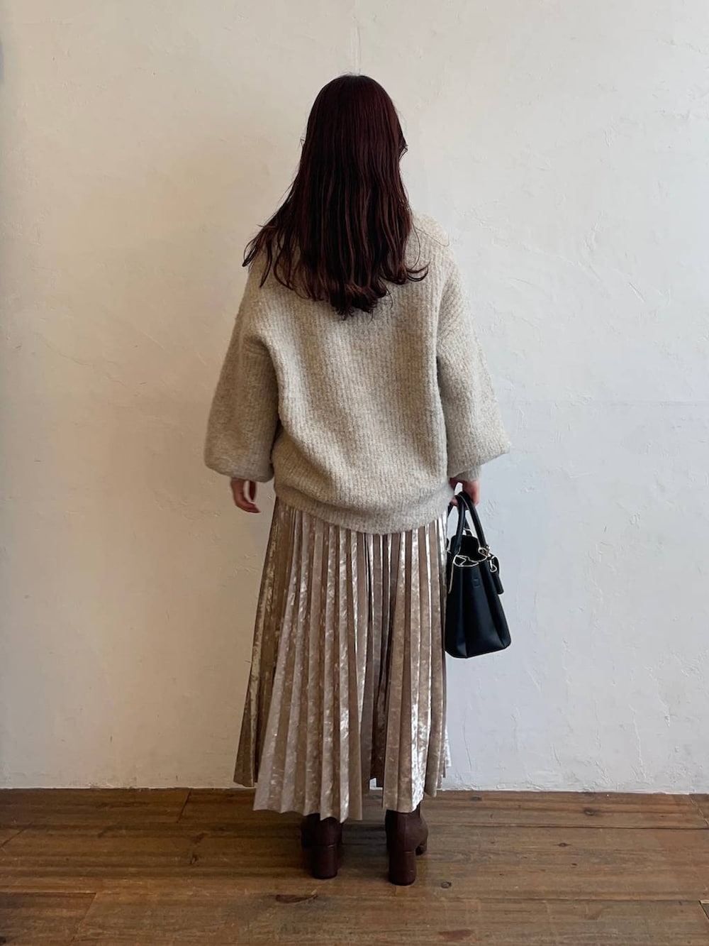 ブラウン系のブーツ、シルバー系のスカート、ホワイト系のカーディガン/ボレロを着用したレディースの冬コーディネートの2枚目の写真