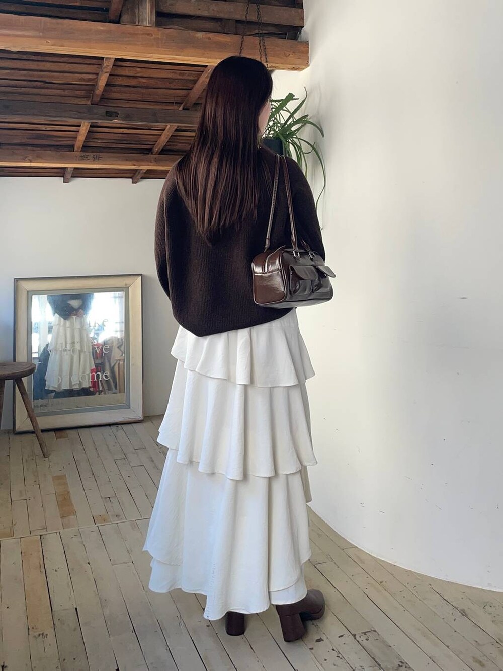 ベージュ系のピーコート、ブラウン系のブーツ、ブラウン系のニット/セーターを着用したレディースの冬コーディネートの4枚目の写真