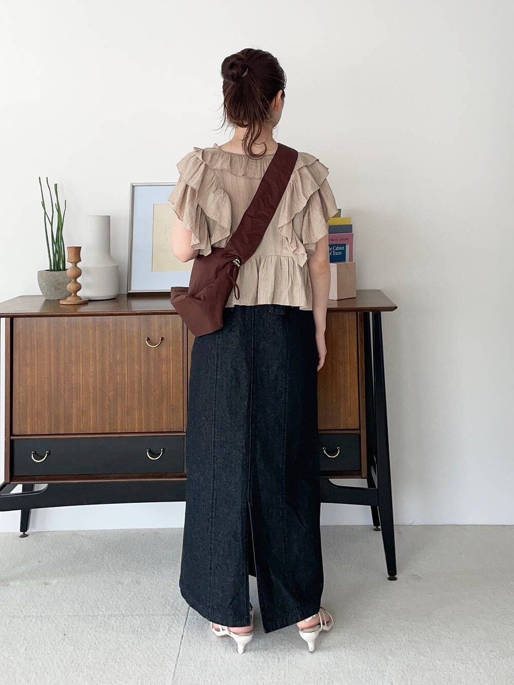 ベージュ系のシャツ/ブラウス、ホワイト系のサンダル、ブラック系のジャンパースカートを着用したレディースの夏コーディネートの2枚目の写真