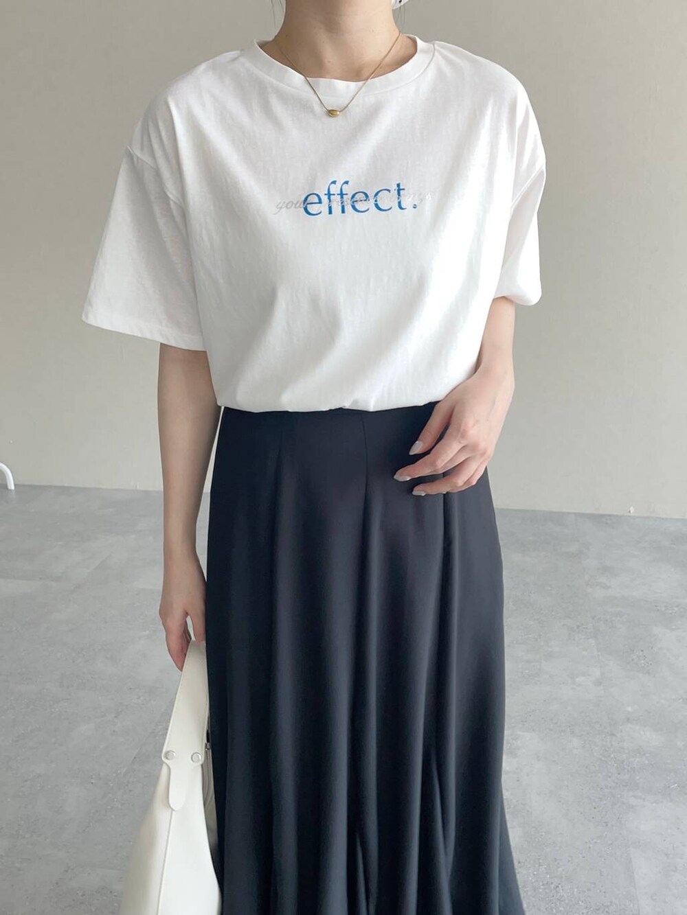 ホワイト系のショルダーバッグ、ホワイト系のTシャツ/カットソー、ブラック系のスカートを着用したレディースの夏コーディネートの3枚目の写真