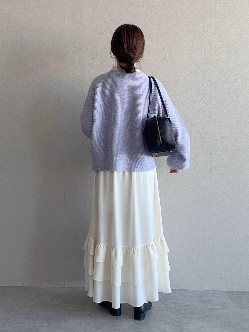 パープル系のニット/セーター、ブラック系のハンドバッグ、ブラック系のローファーを着用したレディースの冬コーディネートの2枚目の写真