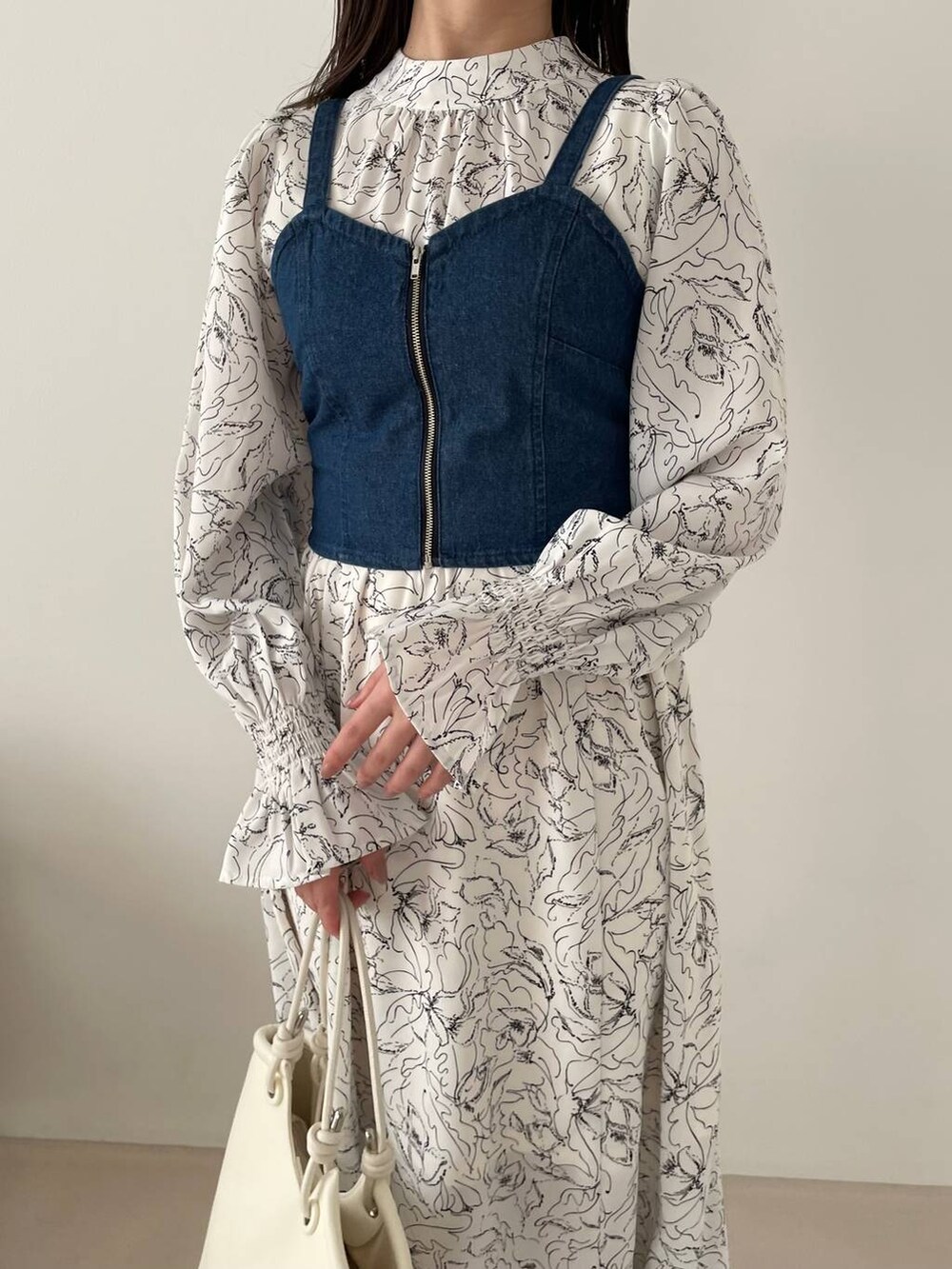 ホワイト系のブーツ、ホワイト系のワンピース、ブルー系のアンサンブルを着用したレディースの春コーディネートの3枚目の写真