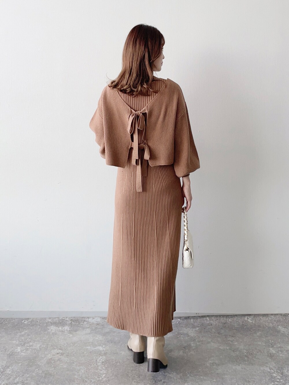 ブラウン系のワンピース、ホワイト系のショルダーバッグ、ベージュ系のブーツを着用したレディースの秋コーディネートの4枚目の写真