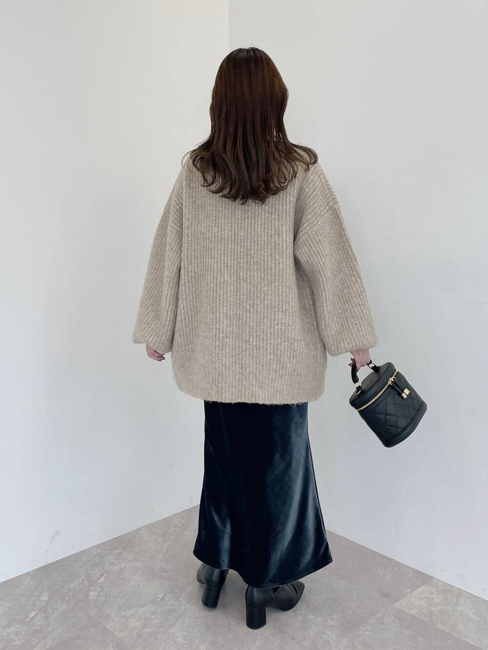 ブラック系のブーツ、ブラック系のショルダーバッグ、ベージュ系のカーディガン/ボレロを着用したレディースの秋コーディネートの2枚目の写真