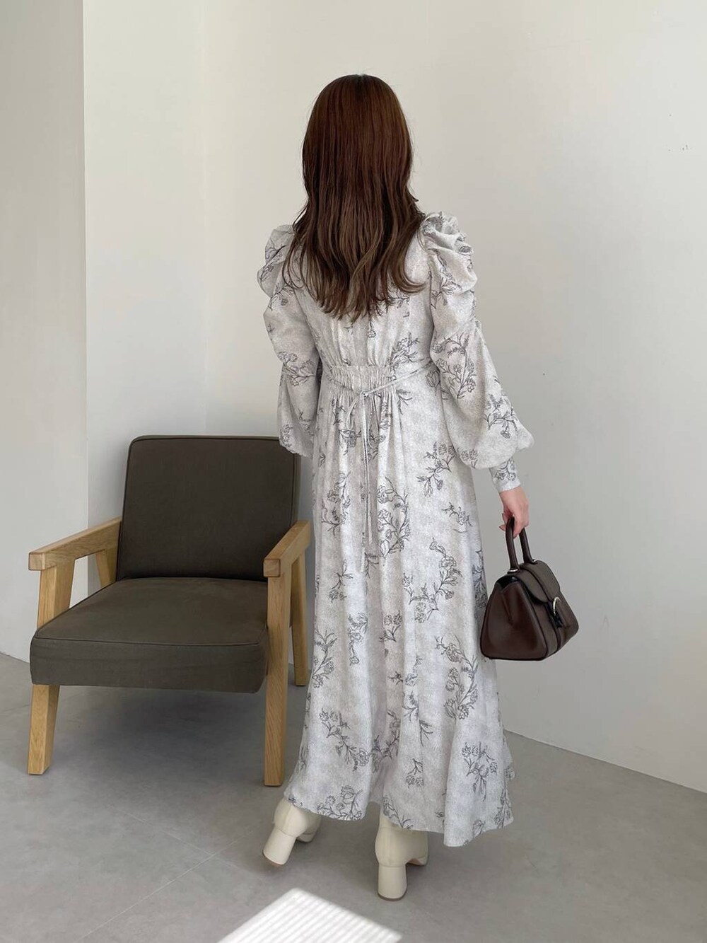 ブラウン系のハンドバッグ、ホワイト系のブーツ、ブラウン系のカーディガン/ボレロを着用したレディースの秋コーディネートの6枚目の写真