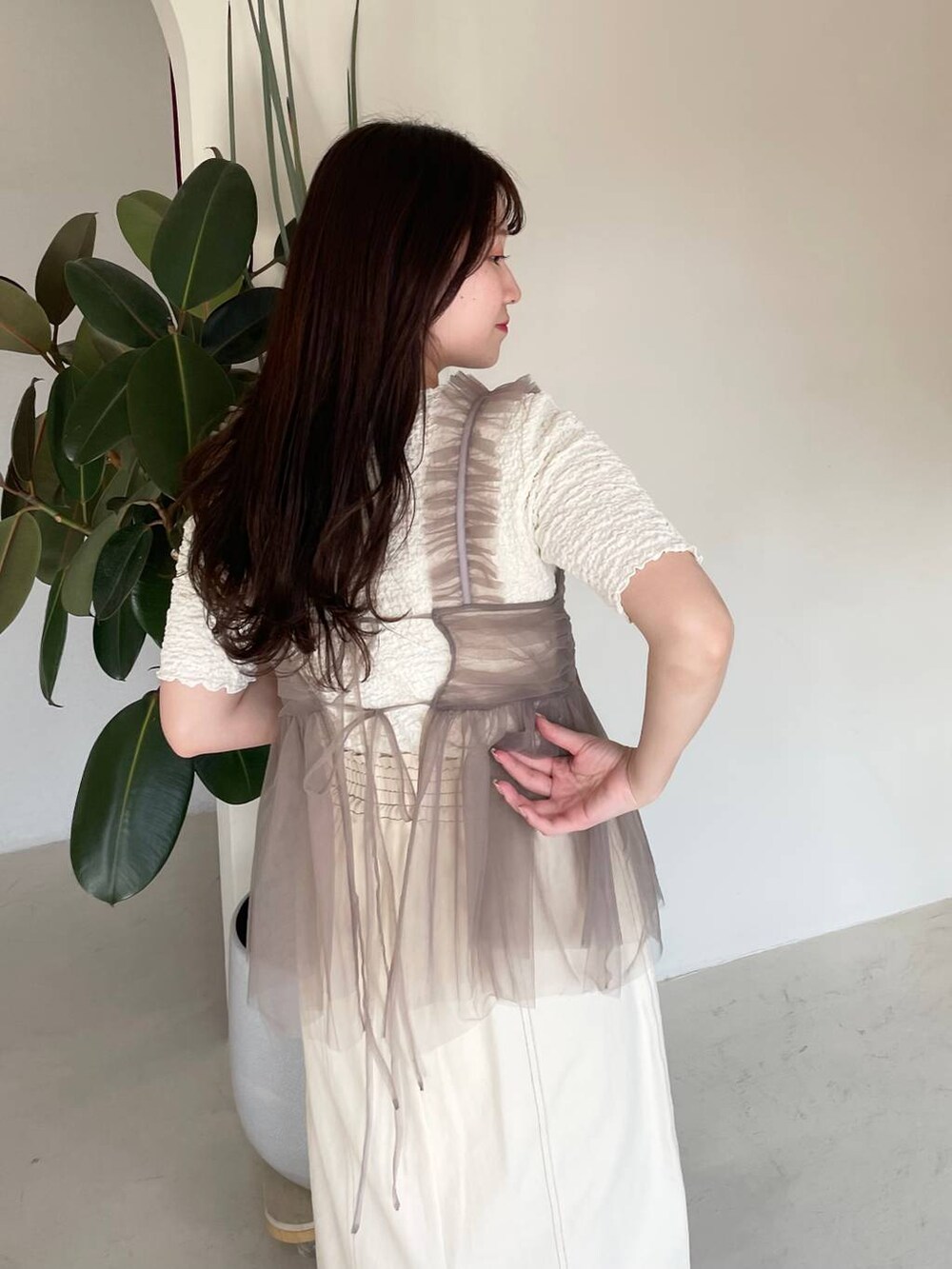 ホワイト系のスカート、ベージュ系のキャミソール、ホワイト系のTシャツ/カットソーを着用したレディースの春コーディネートの6枚目の写真