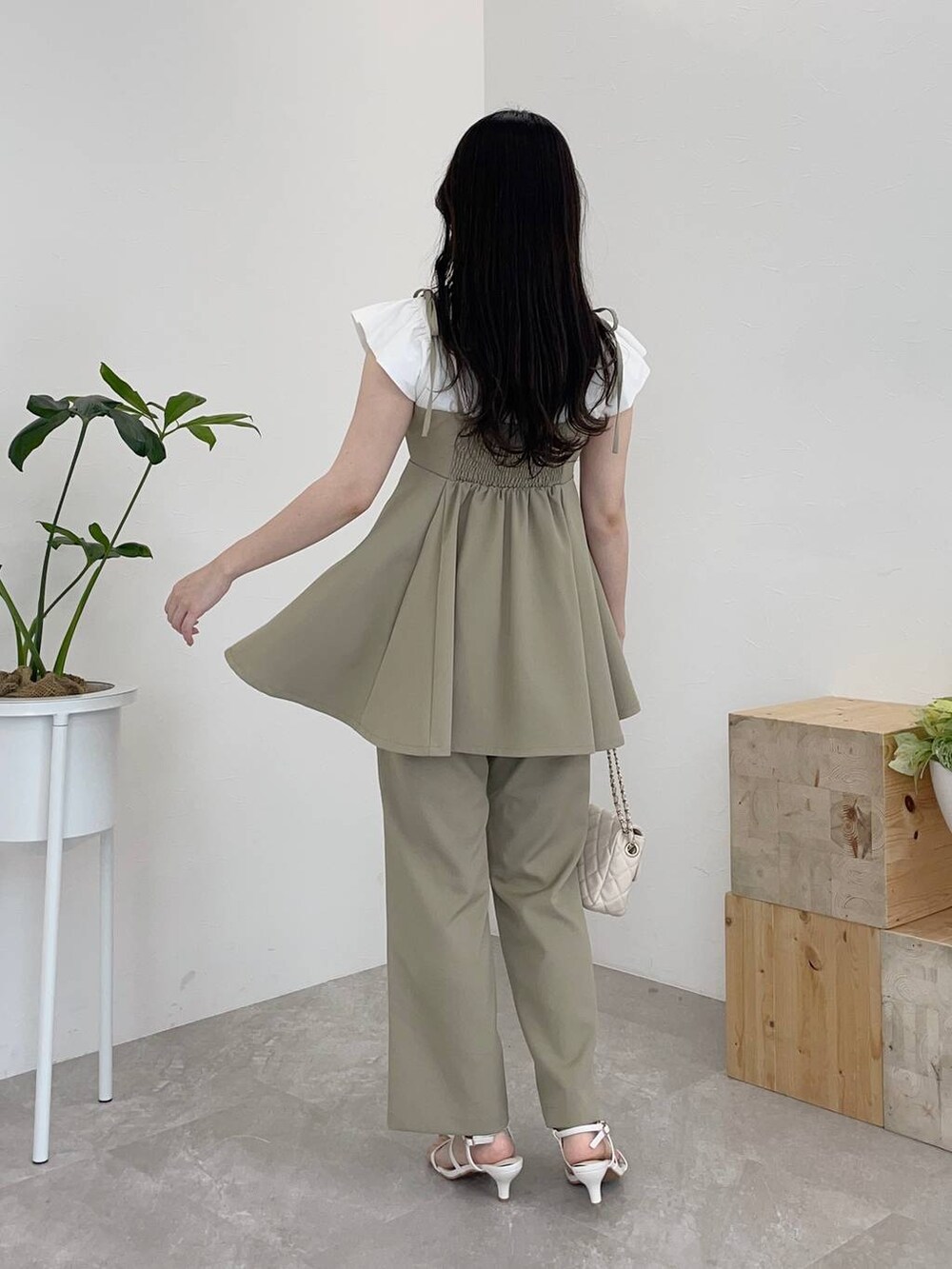 グリーン系のキャミソール、グリーン系のその他パンツ、ホワイト系のショルダーバッグを着用したレディースの春コーディネートの2枚目の写真