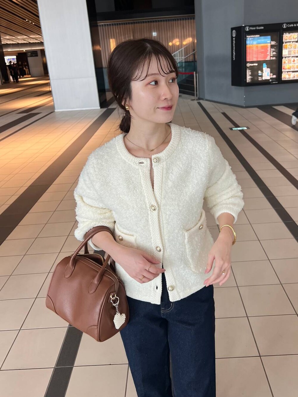 ホワイト系のカーディガン/ボレロ、ブルー系のデニムパンツ、ブラウン系のブーツを着用したレディースの秋コーディネートの4枚目の写真