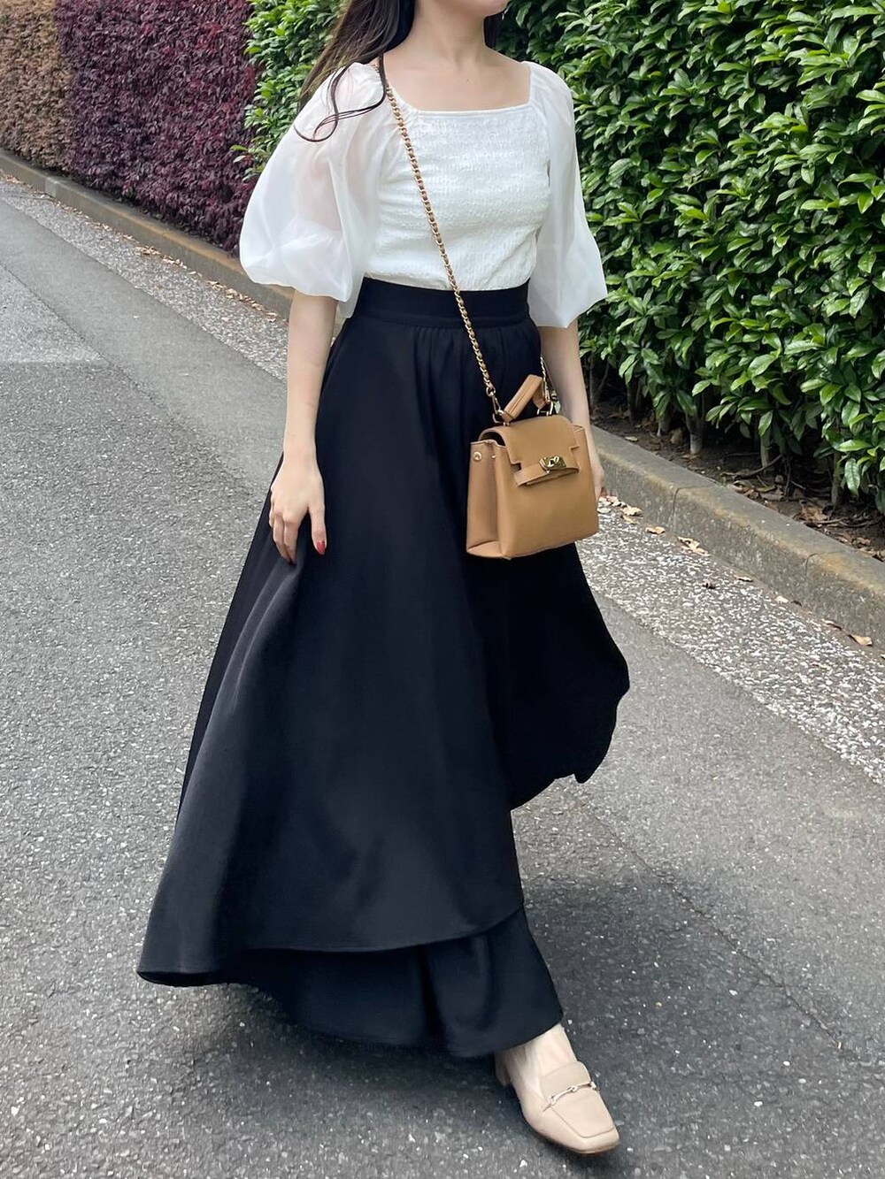 ホワイト系のTシャツ/カットソー、ブラック系のスカート、ブラウン系のショルダーバッグを着用したレディースの春コーディネートの3枚目の写真