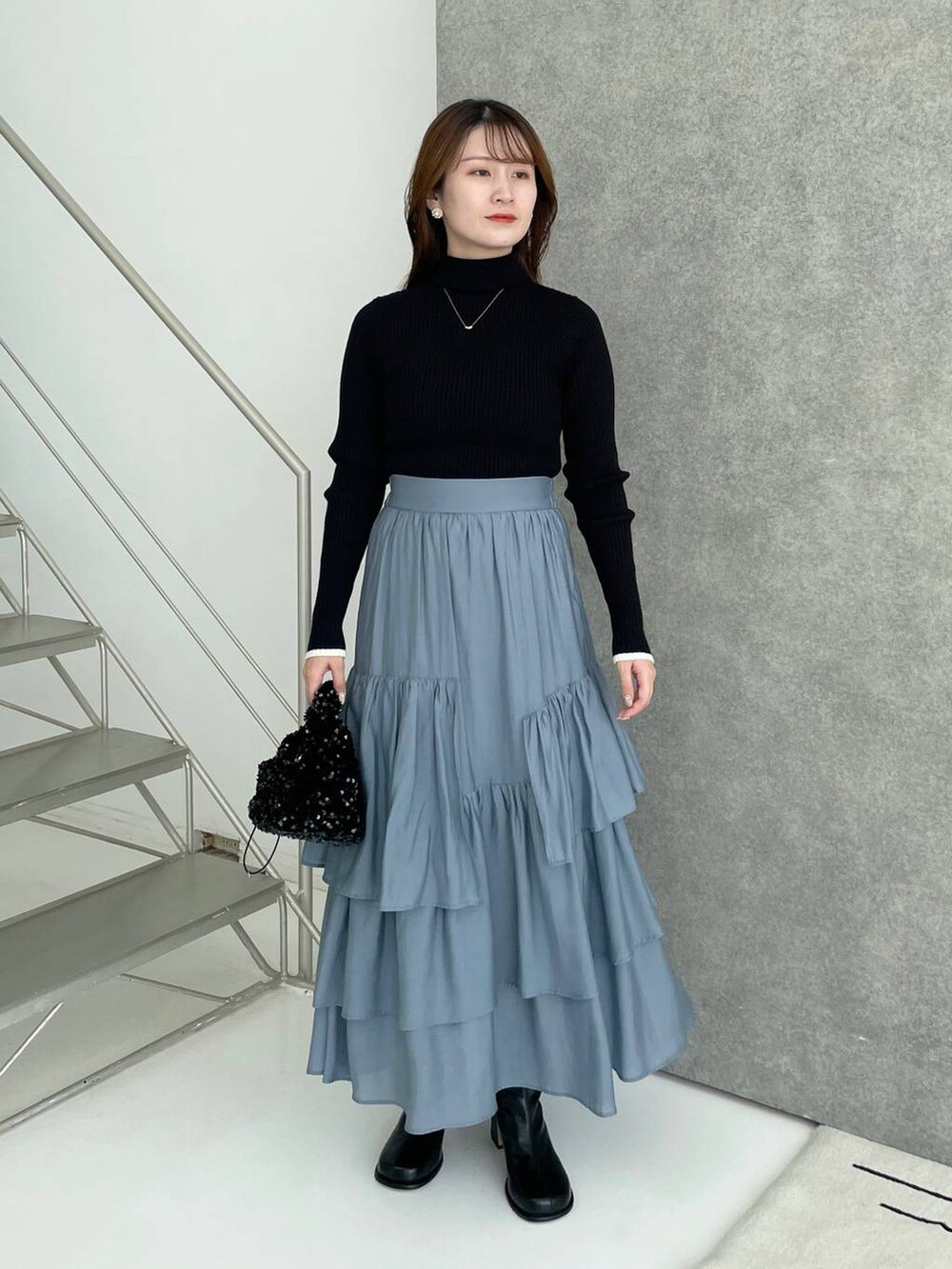 ホワイト系のその他アウター、ブラック系のブーツ、ブルー系のスカートを着用したレディースの秋コーディネートの4枚目の写真