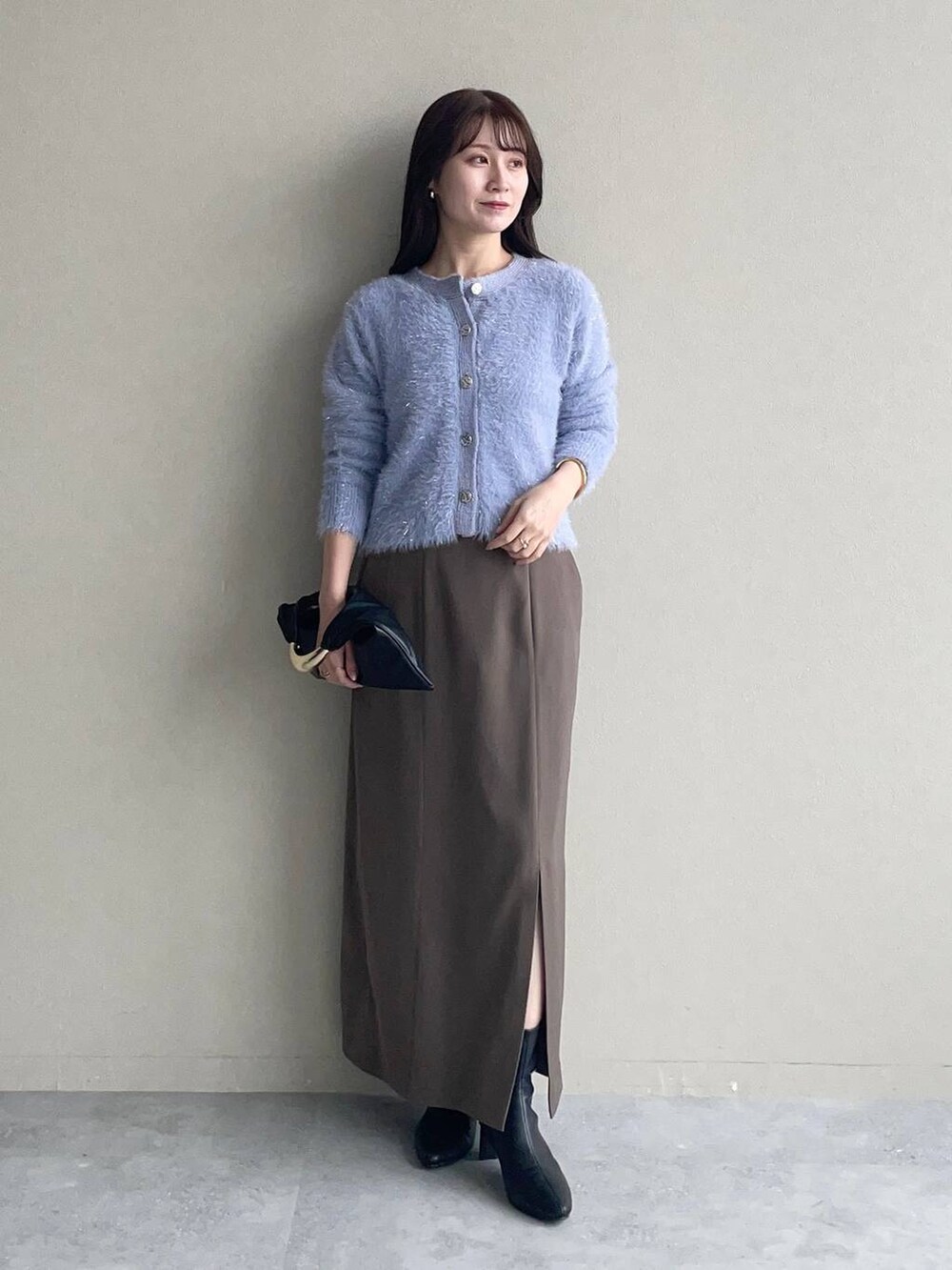 ブラック系のピーコート、ブラック系のハンドバッグ、ブラック系のブーツを着用したレディースの秋コーディネートの3枚目の写真