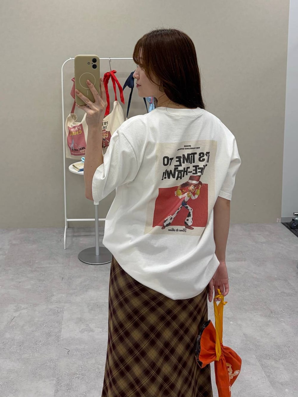 ホワイト系のTシャツ/カットソー、レッド系のスカート、ホワイト系のポーチを着用したレディースの夏コーディネートの2枚目の写真