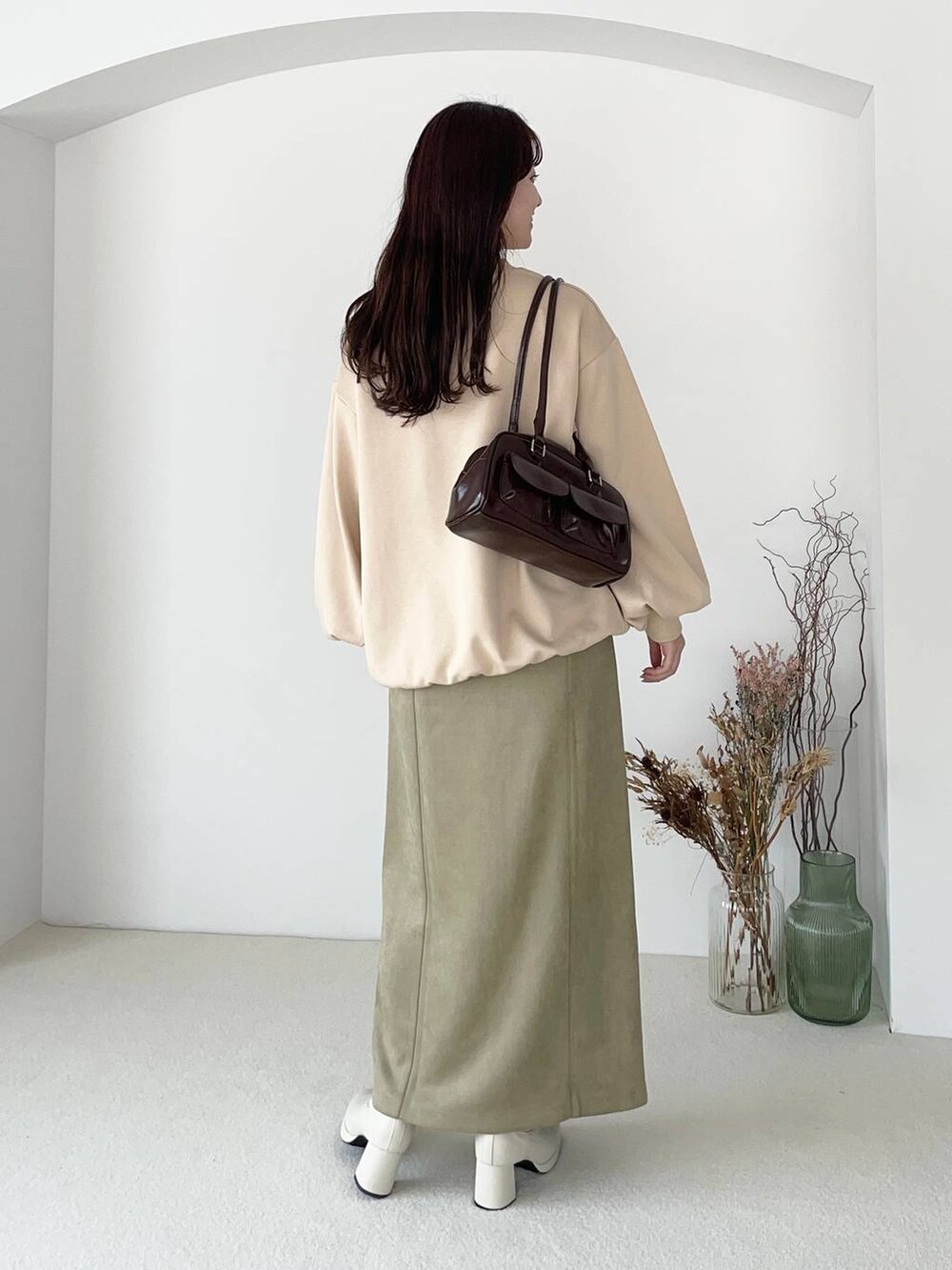 ホワイト系のブーツ、ベージュ系のスカート、ベージュ系のスウェットを着用したレディースの夏コーディネートの2枚目の写真