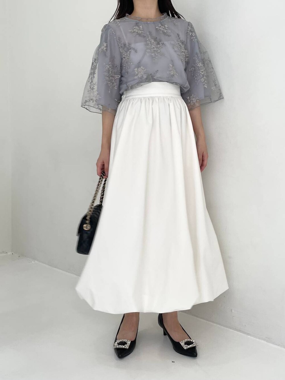 ブラック系のパンプス、ブルー系のシャツ/ブラウス、ブラック系のショルダーバッグを着用したレディースの夏コーディネートの4枚目の写真