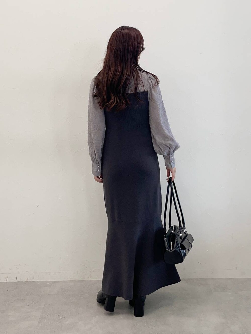 ホワイト系のブルゾン、ブラック系のブーツ、グレー系のワンピースを着用したレディースの秋コーディネートの6枚目の写真