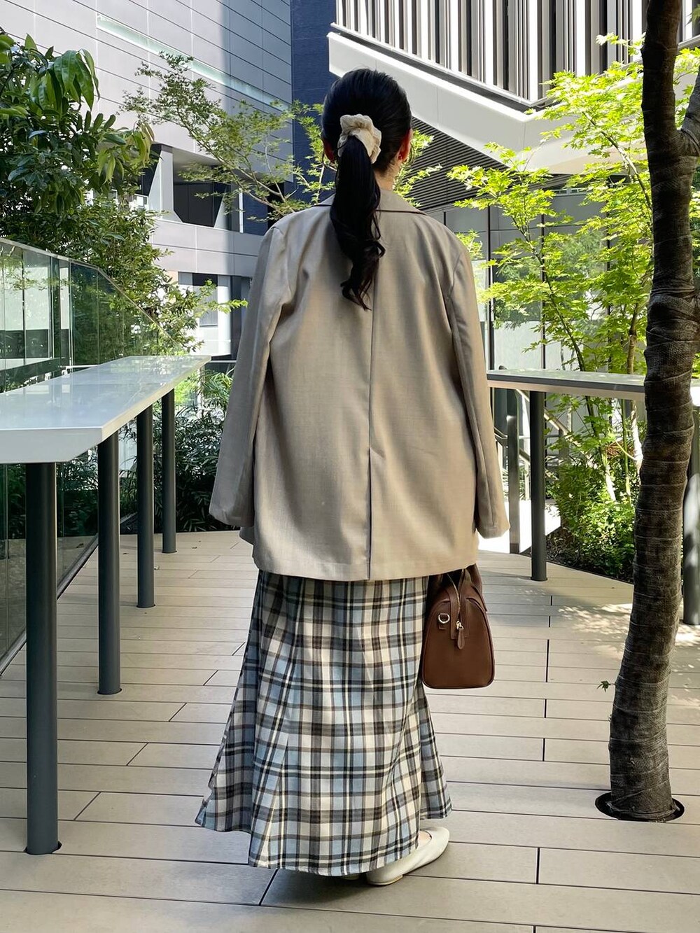 ベージュ系のテーラードジャケット、ブラウン系のショルダーバッグ、ベージュ系のワンピースを着用したレディースの秋コーディネートの2枚目の写真