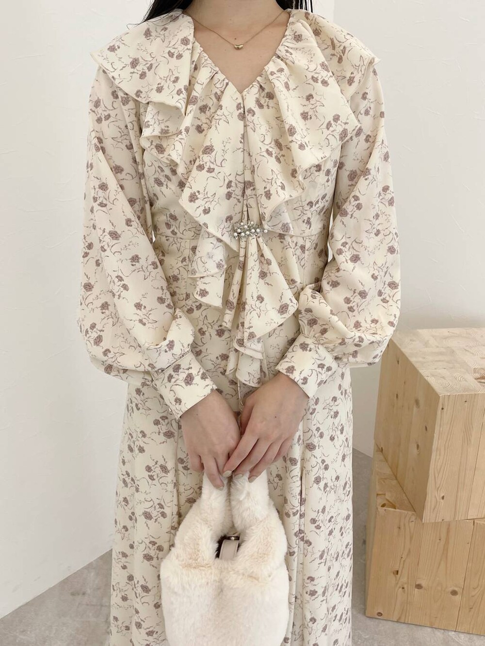 ブラウン系のカーディガン/ボレロ、ホワイト系のハンドバッグ、ブラウン系のブーツを着用したレディースの秋コーディネートの6枚目の写真