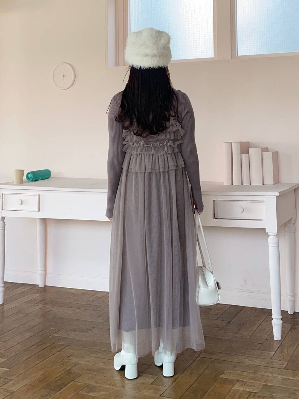 ホワイト系のブーツ、ブラウン系のワンピース、ホワイト系のハンドバッグを着用したレディースの冬コーディネートの2枚目の写真