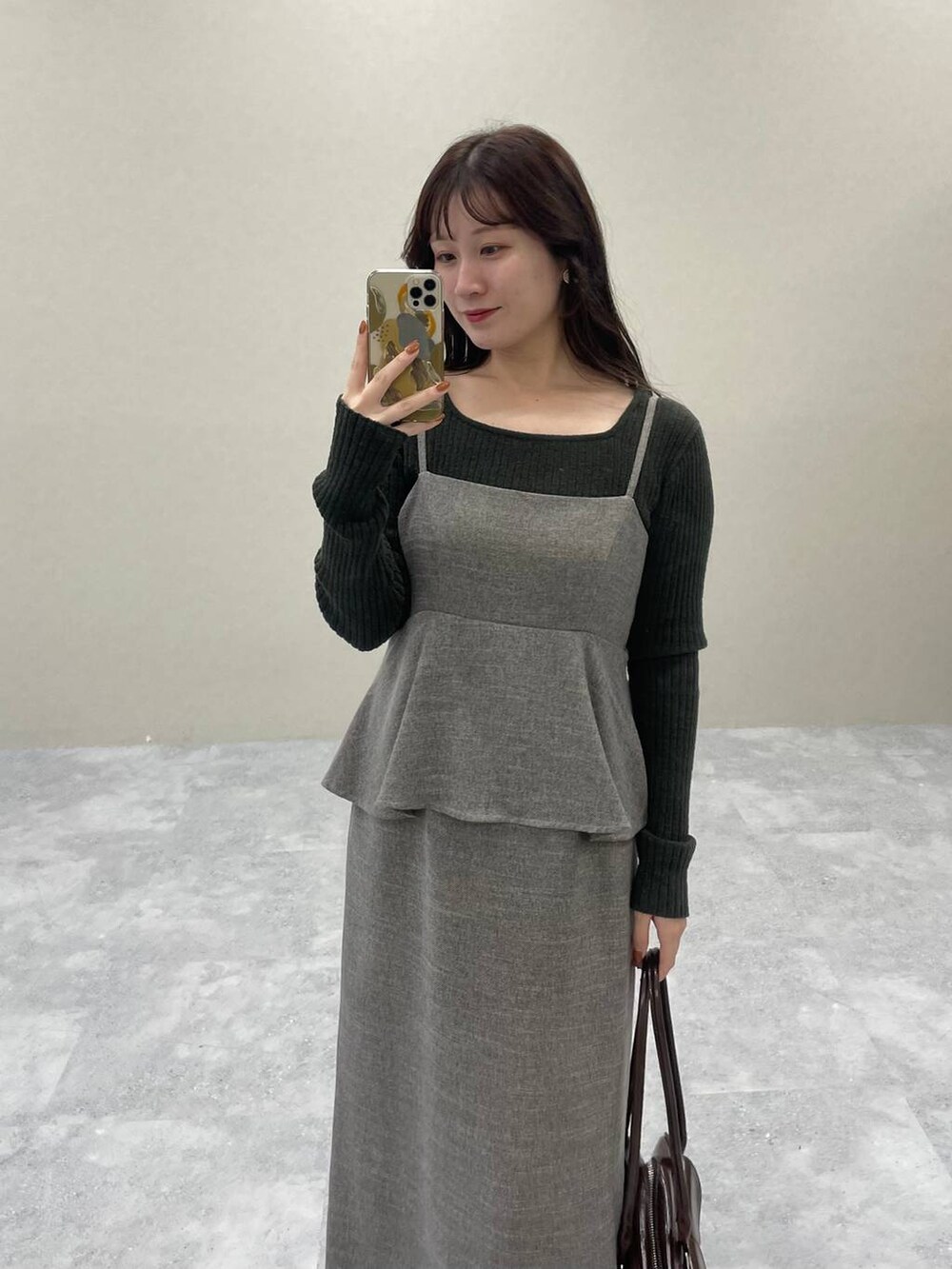 ベージュ系のピーコート、ブラウン系のブーツ、グレー系のワンピースを着用したレディースの秋コーディネートの5枚目の写真