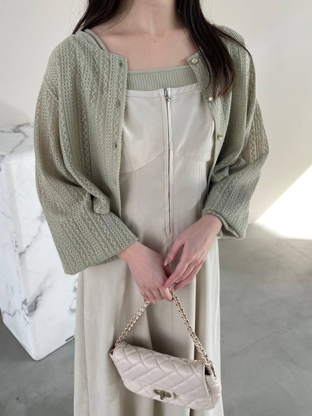 ホワイト系のワンピース、ホワイト系のショルダーバッグ、グリーン系のTシャツ/カットソーを着用したレディースの春コーディネートの3枚目の写真