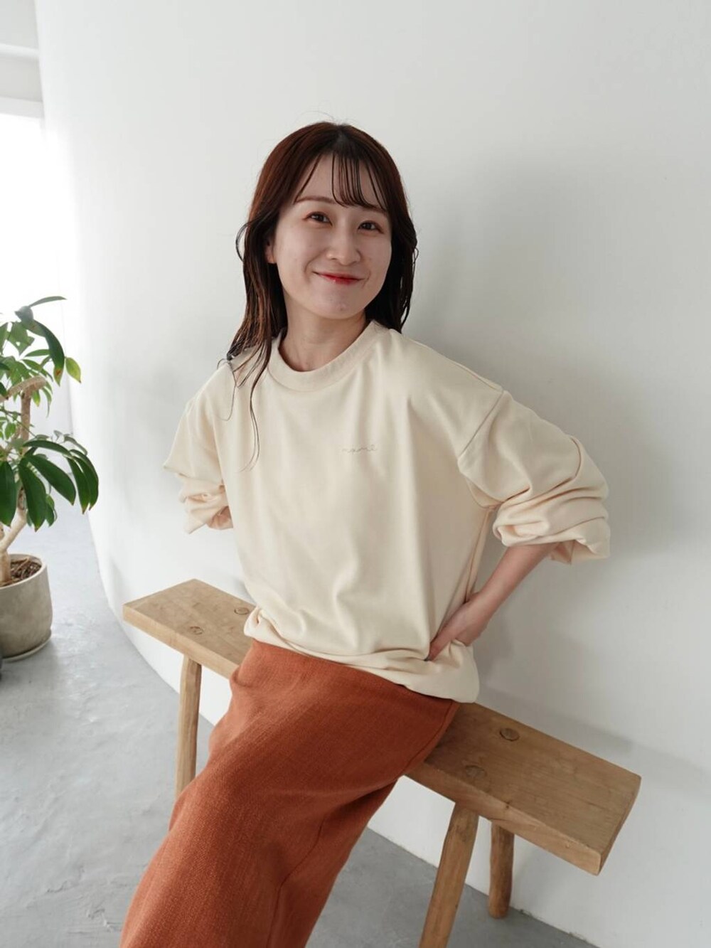 ブラウン系のブーツ、オレンジ系のスカート、ホワイト系のスウェットを着用したレディースの秋コーディネートの3枚目の写真