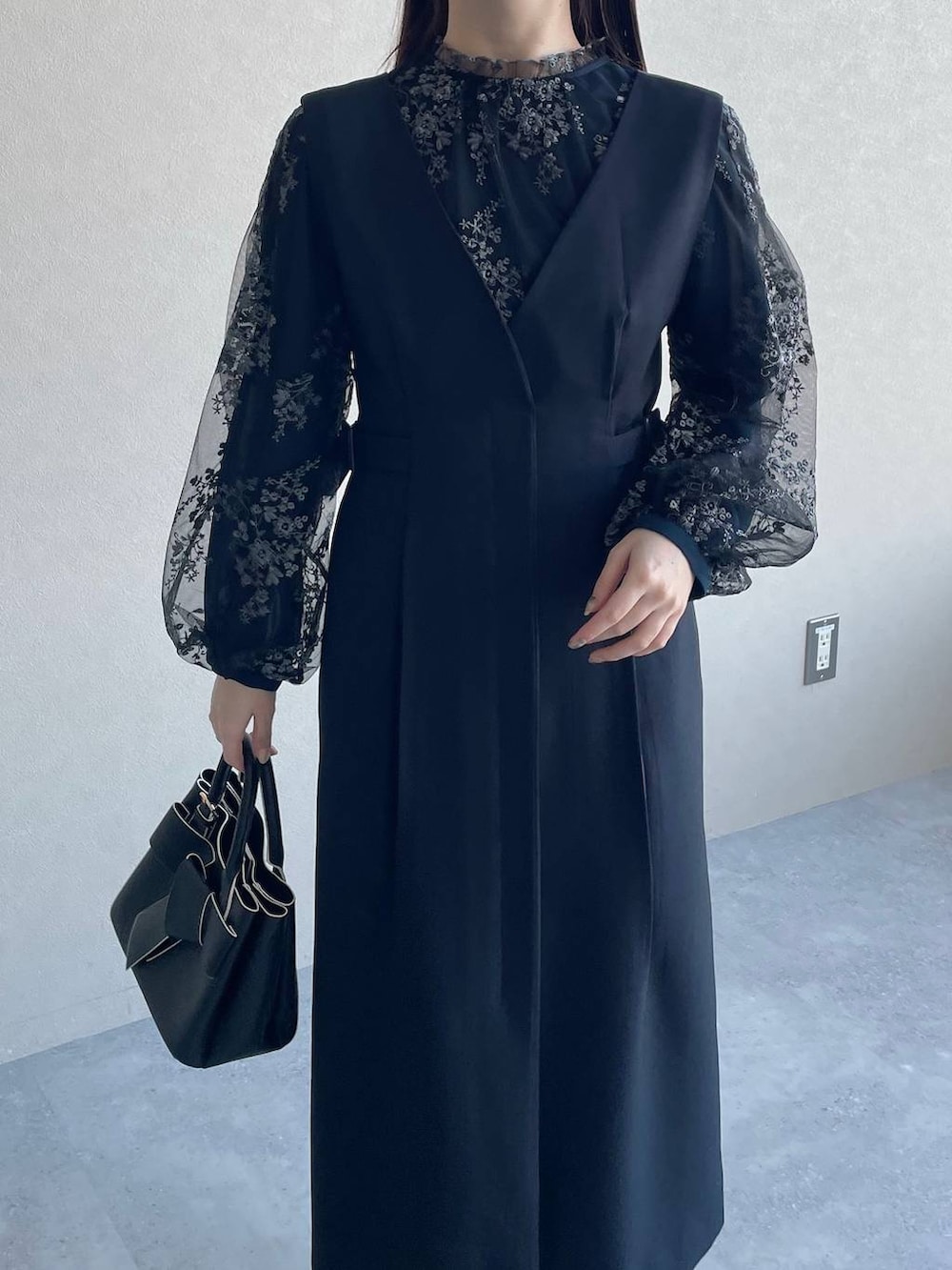 ブラック系のシャツ/ブラウス、ブラック系のショルダーバッグ、ブルー系のジャンパースカートを着用したレディースの冬コーディネートの3枚目の写真