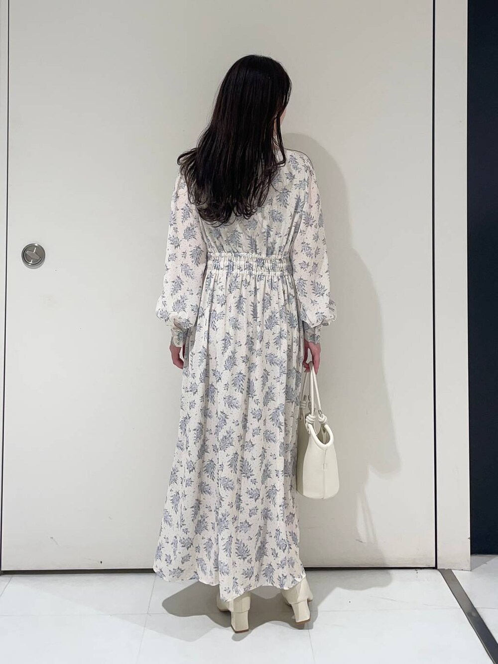 ブルー系のワンピース、ホワイト系のブーツ、グレー系のトレンチコートを着用したレディースの春コーディネートの6枚目の写真