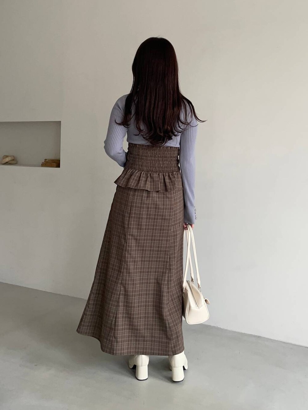 ホワイト系のブルゾン、ホワイト系のブーツ、ブラウン系のスカートを着用したレディースの冬コーディネートの4枚目の写真