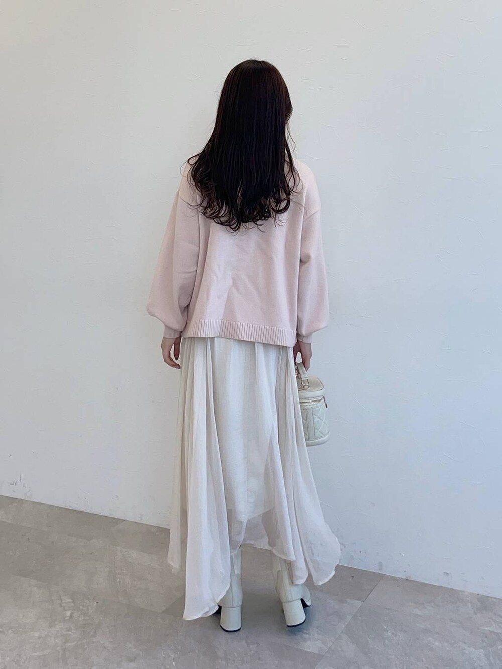 ホワイト系のブーツ、ホワイト系のスカート、ピンク系のニット/セーターを着用したレディースの秋コーディネートの2枚目の写真