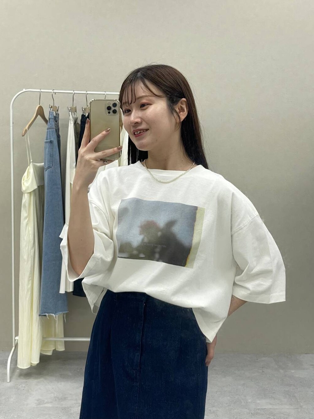 ブラック系のバレエシューズ、ブルー系のスカート、ホワイト系のTシャツ/カットソーを着用したレディースの春コーディネートの2枚目の写真