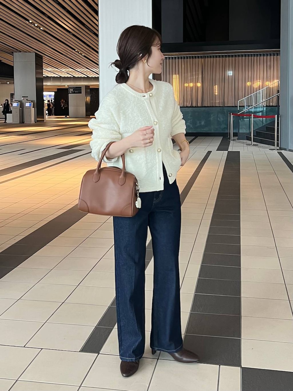 ホワイト系のカーディガン/ボレロ、ブルー系のデニムパンツ、ブラウン系のブーツを着用したレディースの秋コーディネートの3枚目の写真