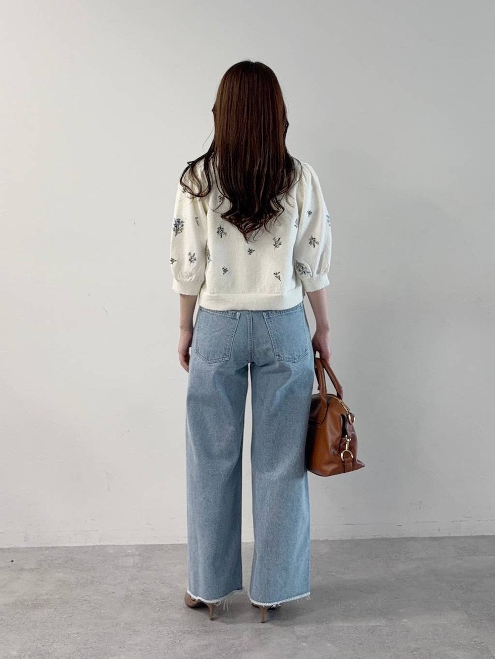 ホワイト系のTシャツ/カットソー、ホワイト系のカーディガン/ボレロ、ブルー系のデニムパンツを着用したレディースの秋コーディネートの2枚目の写真