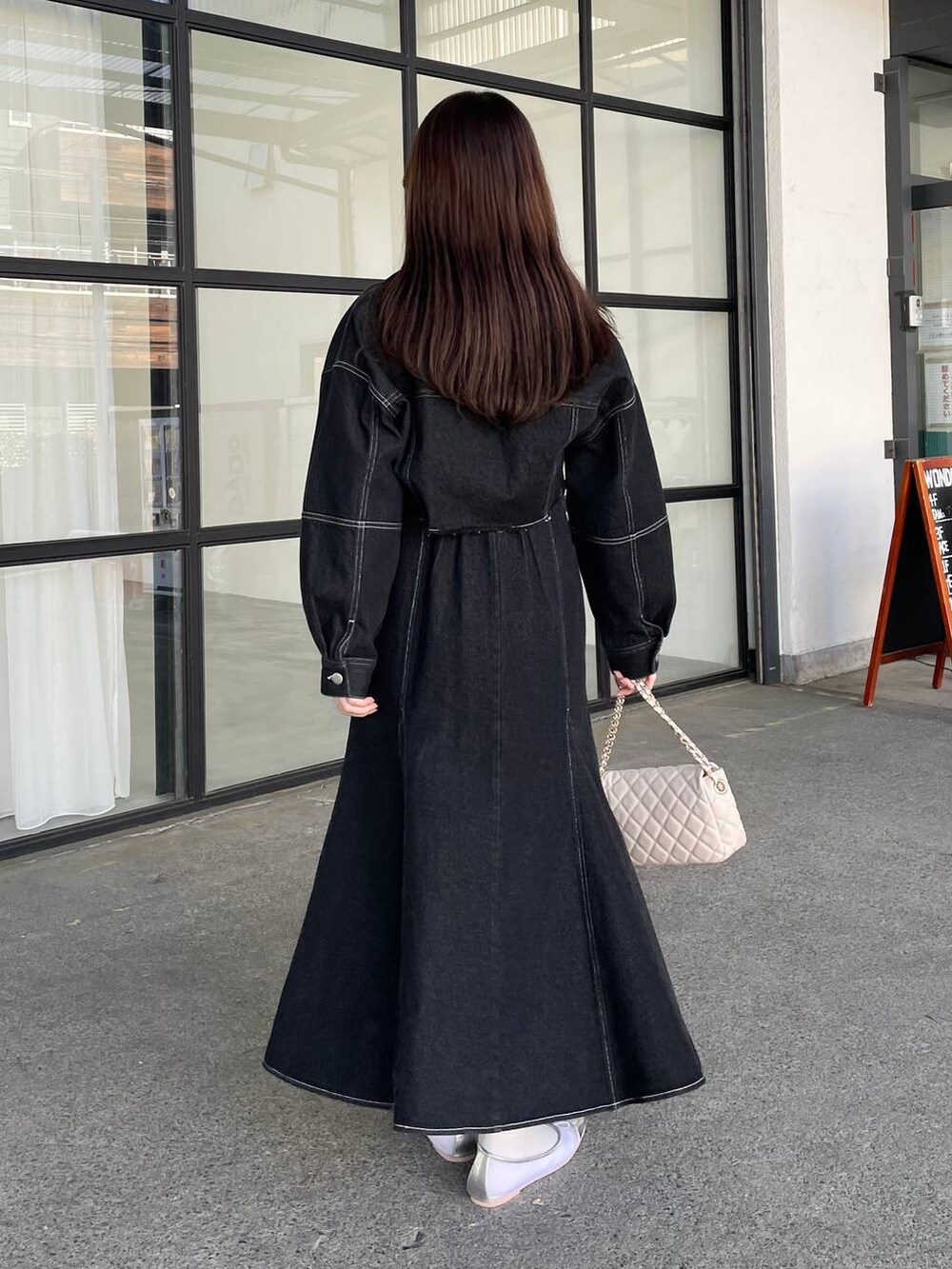 ホワイト系のシャツ/ブラウス、ホワイト系のショルダーバッグ、ブラック系のデニムジャケットを着用したレディースの冬コーディネートの2枚目の写真