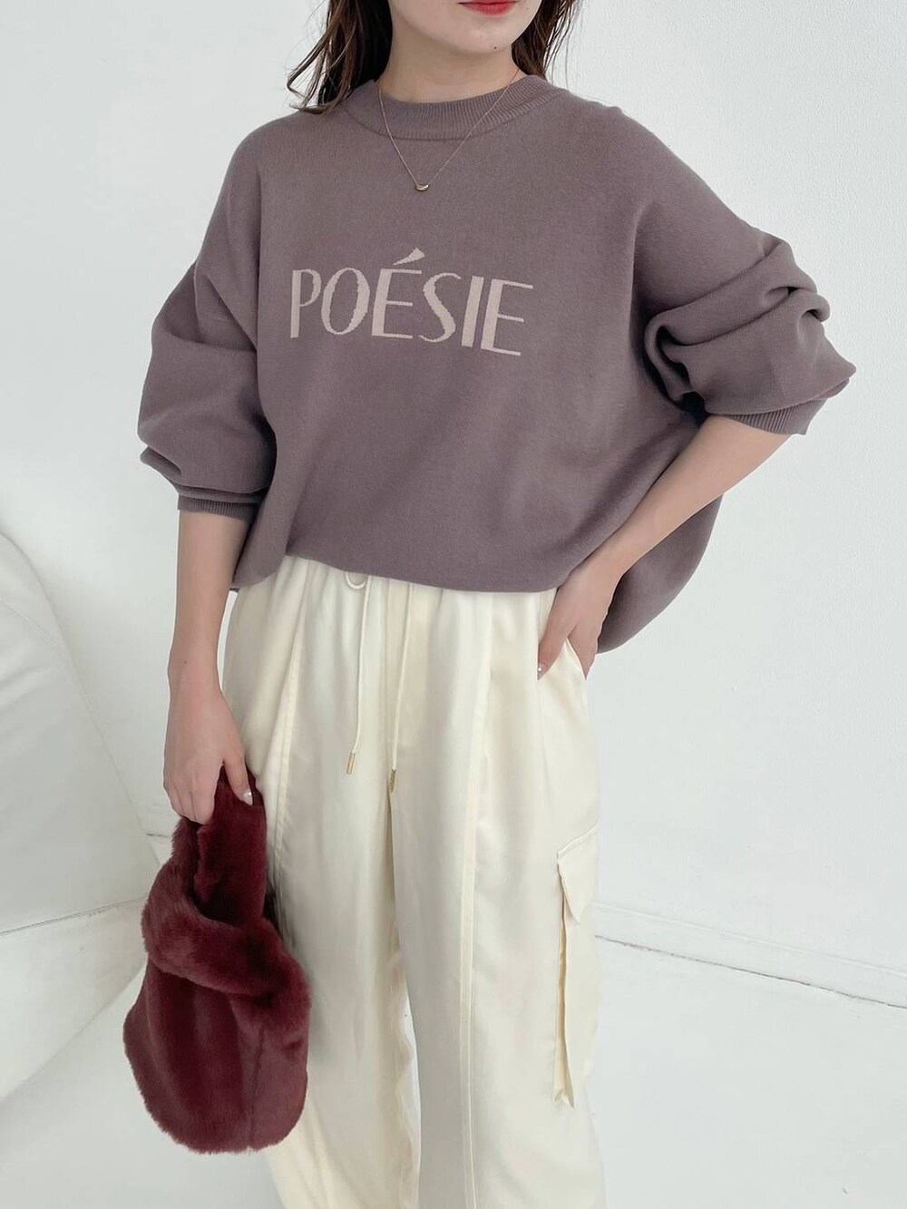 ホワイト系のパンプス、ピンク系のハンドバッグ、ブラウン系のニット/セーターを着用したレディースの秋コーディネートの3枚目の写真