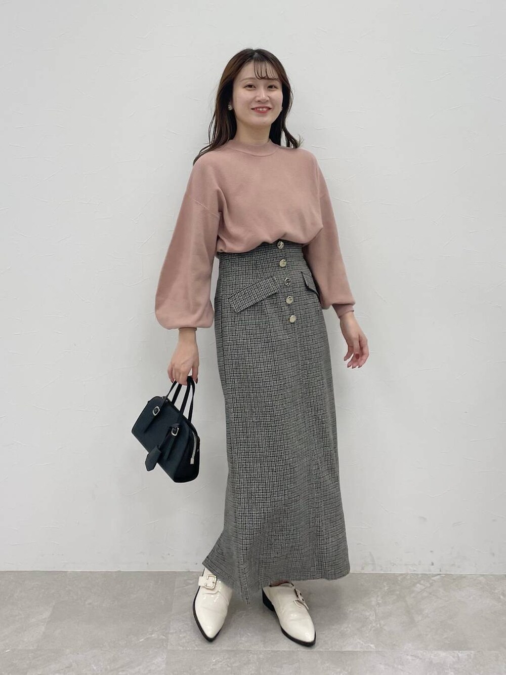 ブラック系のボストンバッグ、ホワイト系のその他シューズ、ピンク系のニット/セーターを着用したレディースの秋コーディネートの4枚目の写真