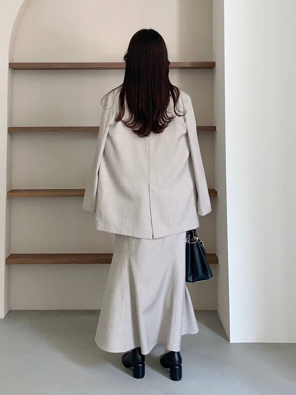 ブラック系のショルダーバッグ、ホワイト系のシャツ/ブラウス、ブラック系のパンプスを着用したレディースの冬コーディネートの2枚目の写真