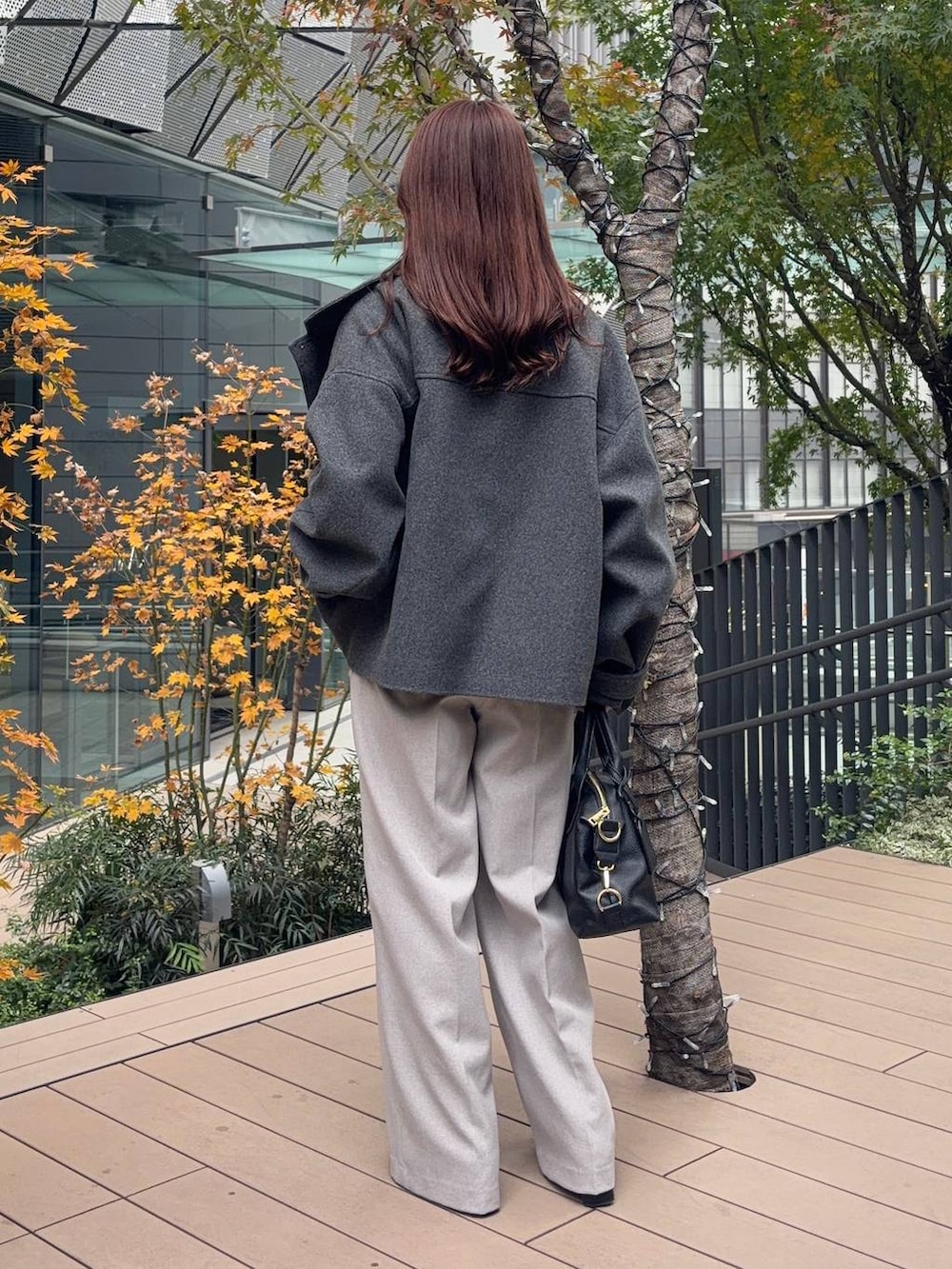 グレー系のピーコート、ピンク系のニット/セーター、ブラック系のボストンバッグを着用したレディースの冬コーディネートの2枚目の写真