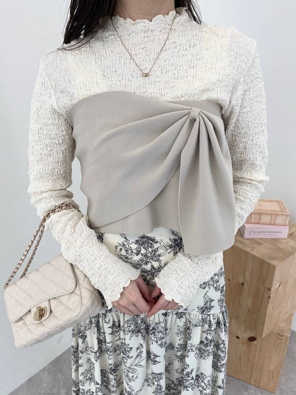 ホワイト系のショルダーバッグ、ホワイト系のスカート、ホワイト系のTシャツ/カットソーを着用したレディースの冬コーディネートの3枚目の写真