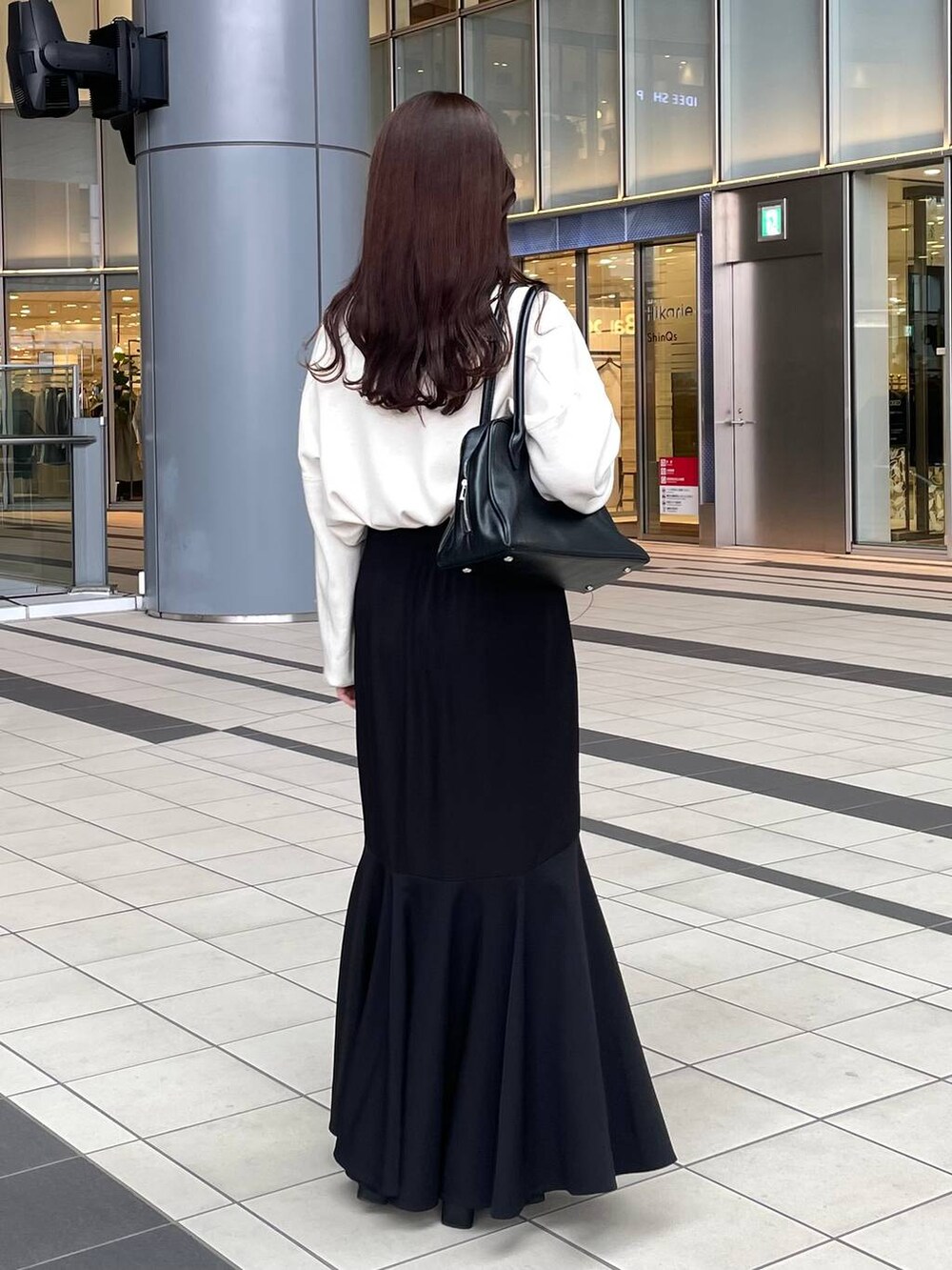 ホワイト系のニット/セーター、ホワイト系のチェスターコート、ブラック系のブーツを着用したレディースの秋コーディネートの6枚目の写真