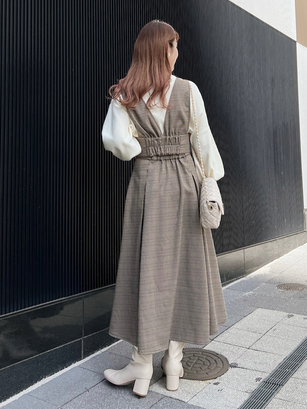 ブラウン系のワンピース、ホワイト系のショルダーバッグ、ホワイト系のニット/セーターを着用したレディースの秋コーディネートの2枚目の写真