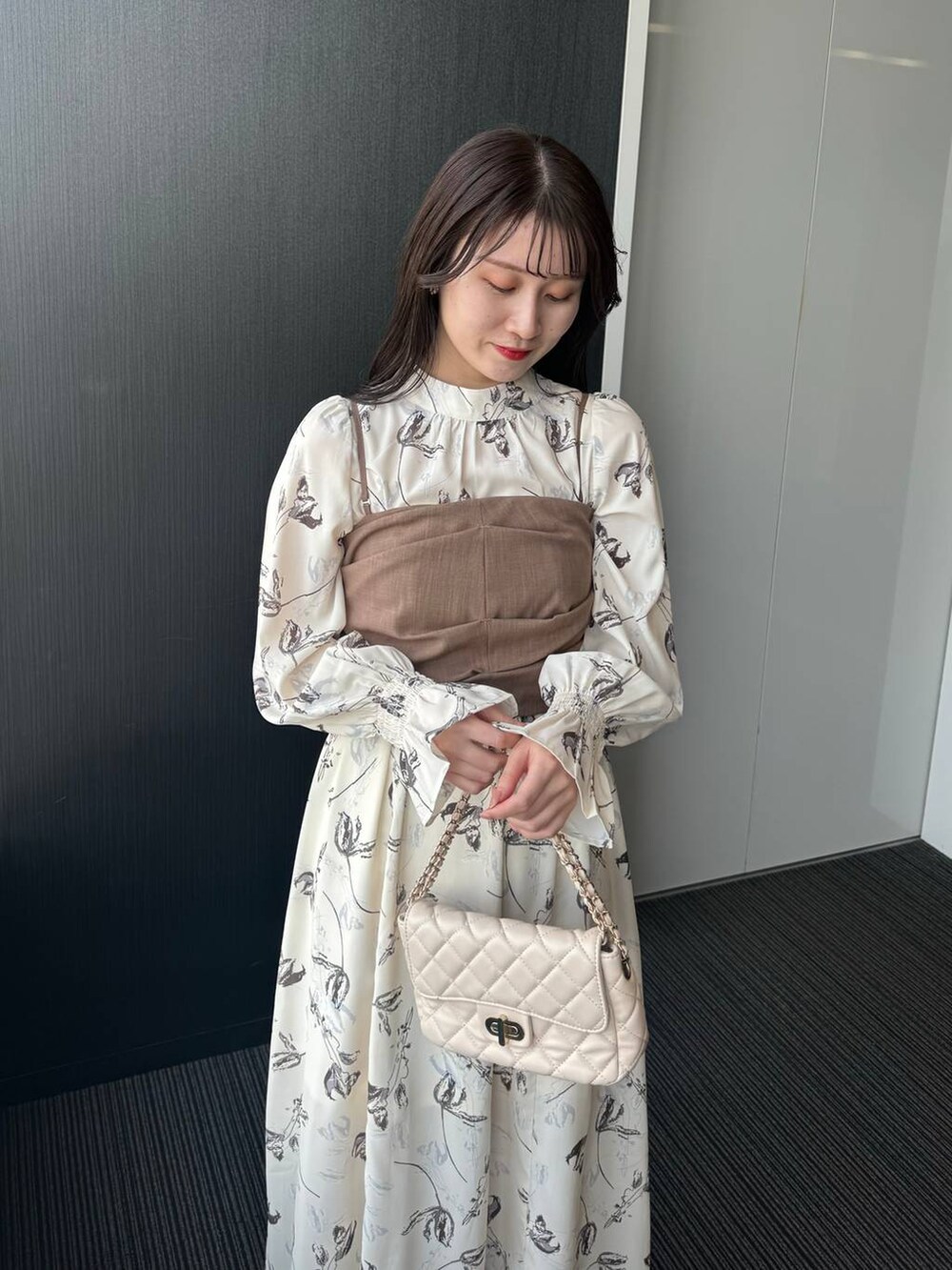 ホワイト系のショルダーバッグ、ホワイト系のワンピース、ホワイト系のブーツを着用したレディースの冬コーディネートの4枚目の写真