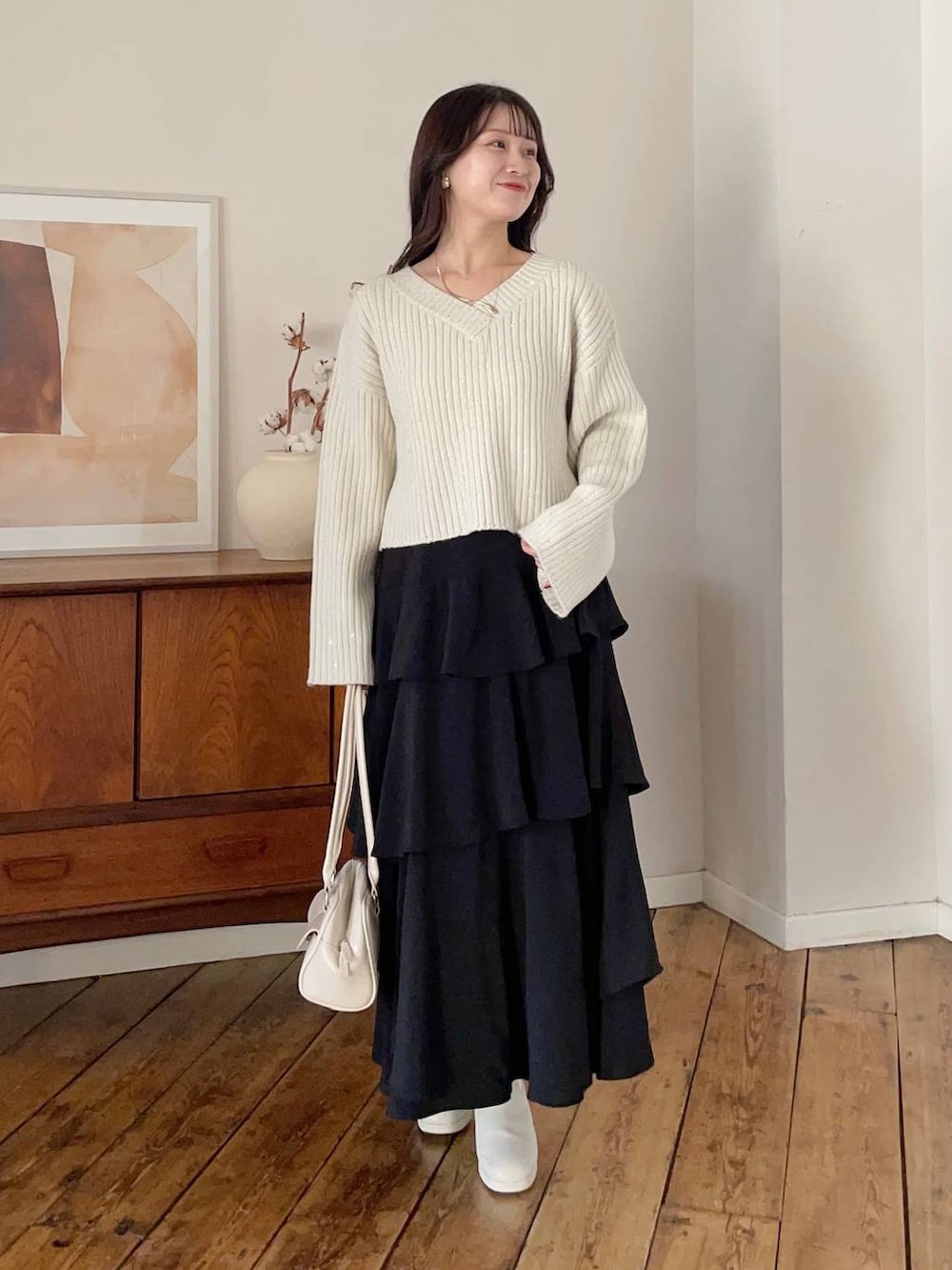 ホワイト系のブーツ、ブラック系のスカート、ブラウン系のブルゾンを着用したレディースの冬コーディネートの3枚目の写真