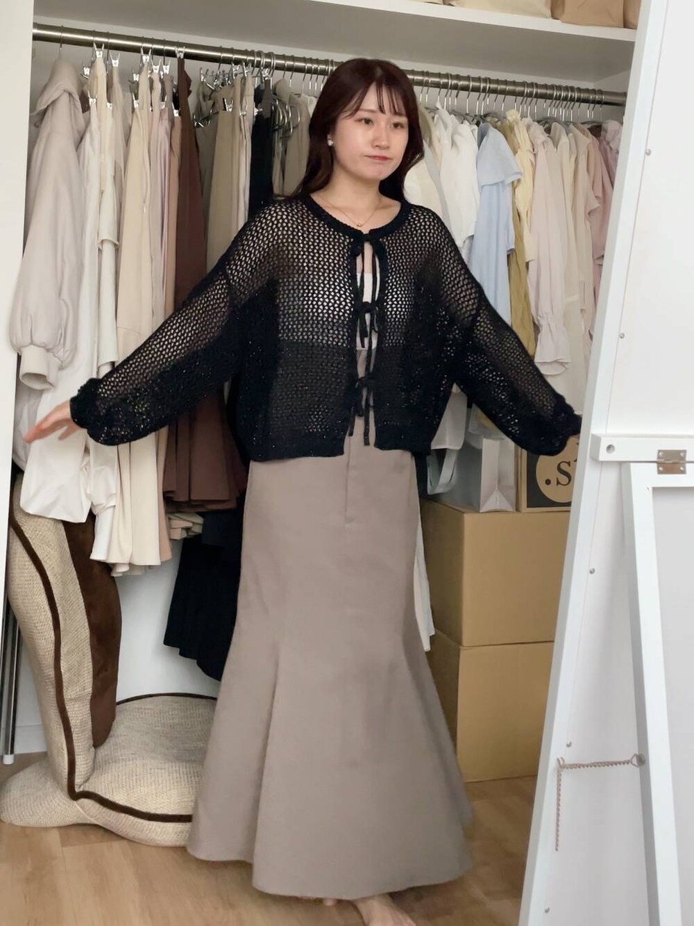 ブラック系のニット/セーター、ベージュ系のスカートを着用したレディースの夏コーディネートの3枚目の写真