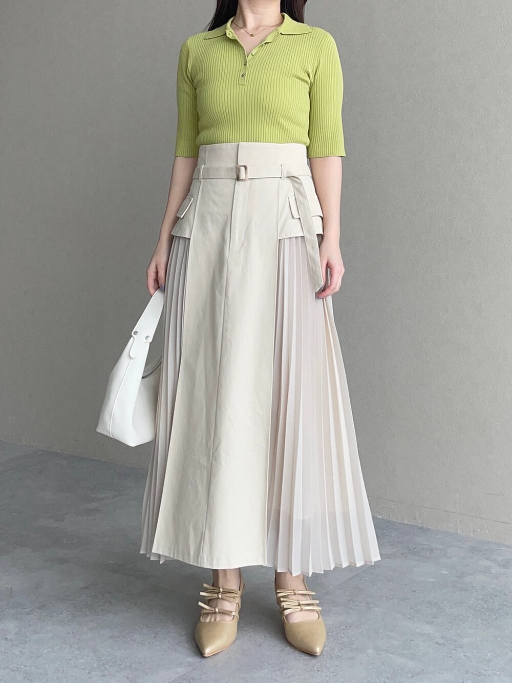 ホワイト系のスカート、グリーン系のニット/セーター、ホワイト系のショルダーバッグを着用したレディースの春コーディネートの4枚目の写真