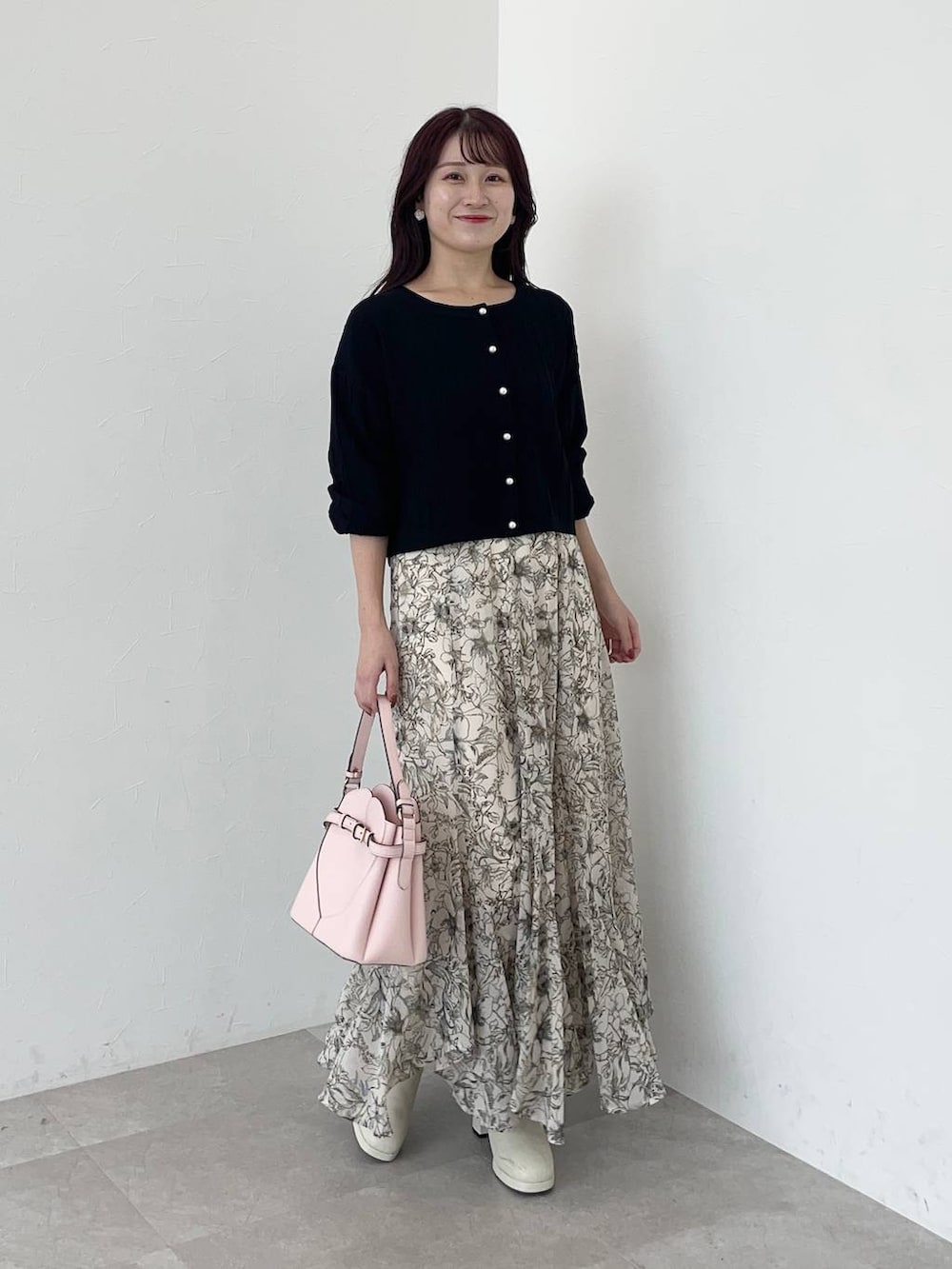 ベージュ系のピーコート、ピンク系のショルダーバッグ、ホワイト系のスカートを着用したレディースの秋コーディネートの4枚目の写真