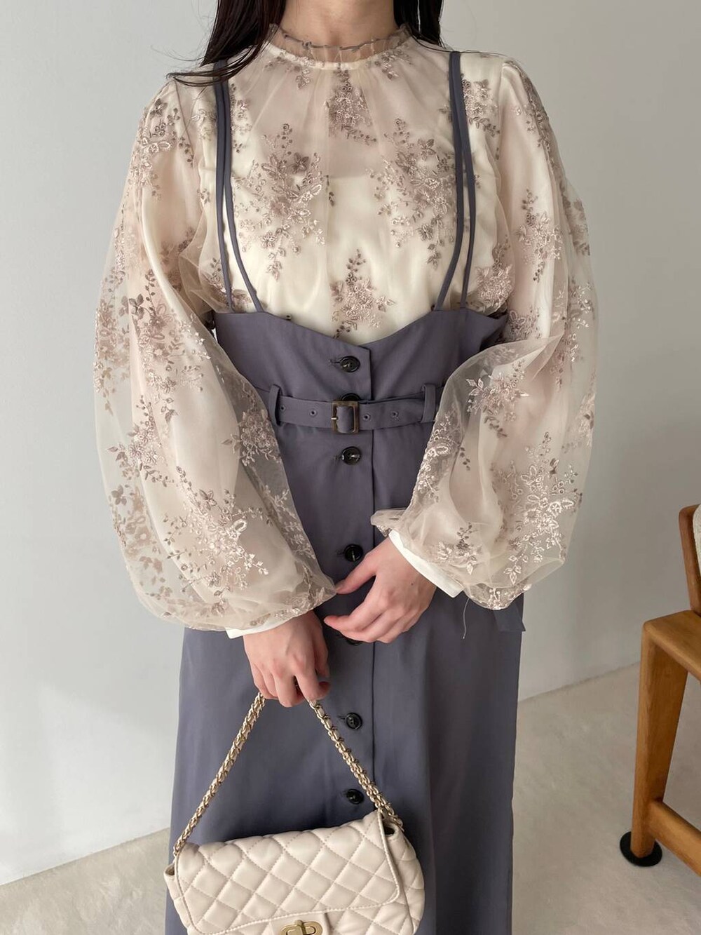 シルバー系のバレエシューズ、ホワイト系のショルダーバッグ、グレー系のスカートを着用したレディースの冬コーディネートの3枚目の写真